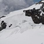 Tři sebevrazi sestupují odpoledním rozměklým sněhem lavinózním svahem z Lyskammu.